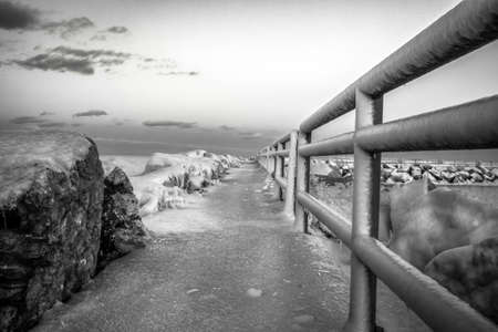 Michigan Winter Landscape.  Frozen walkway on a pier jutting into the icy waters of Lake Huron in Michigan.. Black and white in horizontal orientation. Lexington, Michiganの写真素材