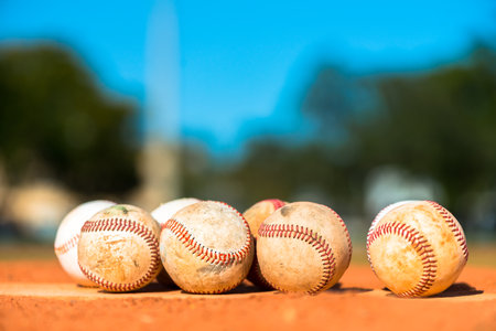 Several baseballs on Pitcher's Mound with blue sky in background
