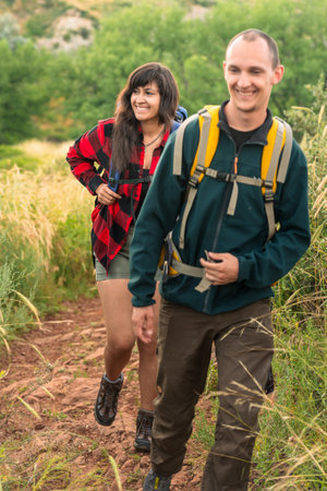 Young couple man and woman hiking trail in Colorado wilderness.