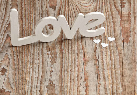 Different size baubles on wooden table and love signの写真素材