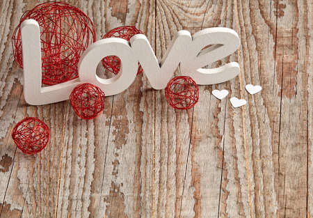 Different size baubles on wooden table and love signの写真素材