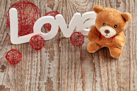 White love sign on wooden background with teddy bear and baubleの写真素材