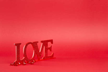 Red background with big glitter love sign and crystal hearts confettiの写真素材