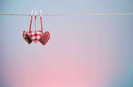 Three plush hearts on blue and pink backgroundの写真素材