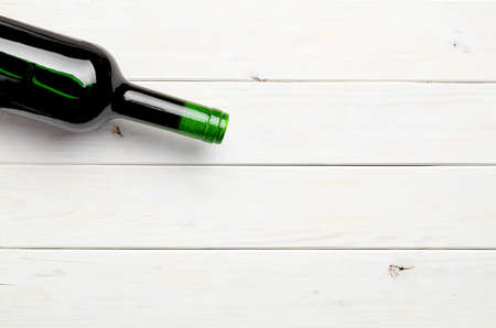 Bottle of red wine on a white wooden backgroundの写真素材