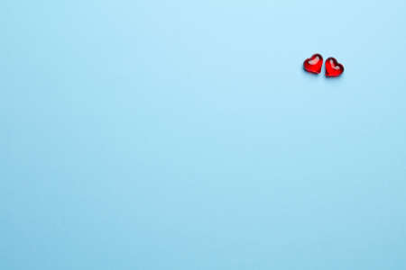 Plain blue background with two little, red heartの写真素材