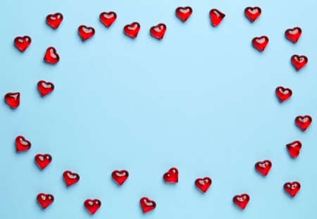 Plain blue background with frame made of little, red heartsの写真素材