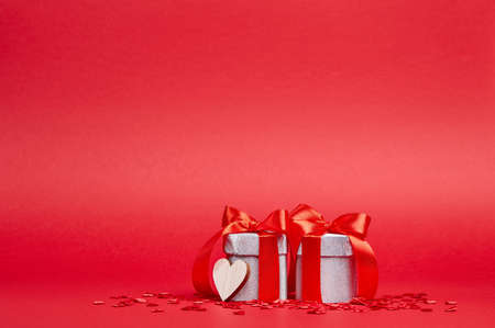 Red background with silver gifts and confettiの写真素材