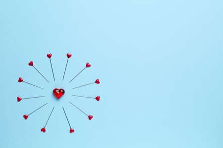 Blue empty background with little heart surrounded by pinsの写真素材