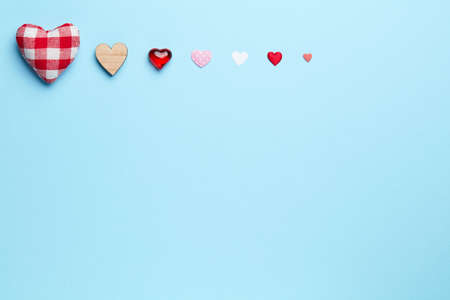 Different size heart figures in line on a plain blue background