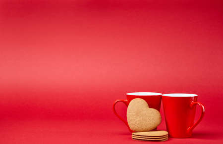 Red background with two cups and gingerbreadの写真素材