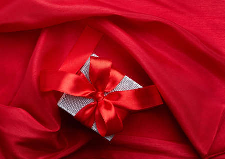 Two gifts with ribbon on red silky fabricの写真素材