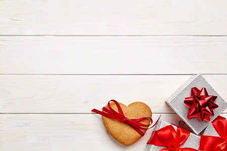 White wooden background with silver gifts and gingerbreadの写真素材