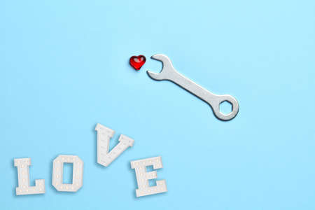 Blue empty background with wrench fixing little red heart and loveの写真素材