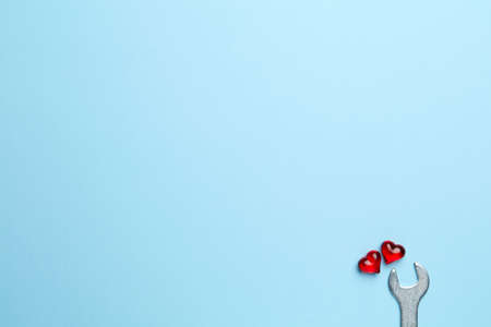 Blue empty background with wrench fixing little red heartの写真素材