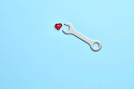 Blue empty background with wrench fixing little red heartの写真素材