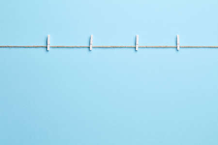 Blue empty background with sting and clothes pegの写真素材