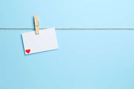 Blue background with empty sting clothes peg and love letterの写真素材