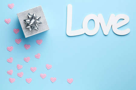 Plain blue background with love, silver gift and little heartsの写真素材