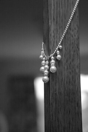 Pearl necklace hanging on wooden postの写真素材