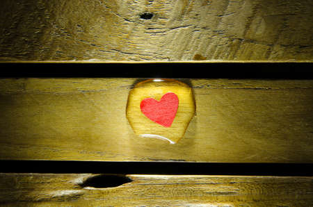 Red heart in water drop on wood pattern.の写真素材
