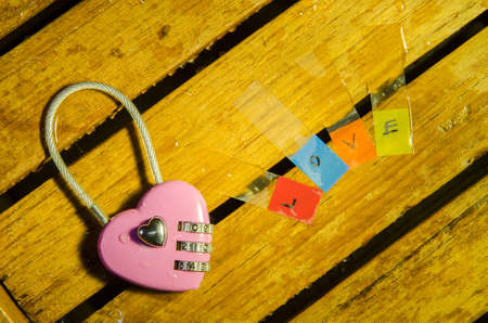 Pink master key and love alphabet on wood pattern backgroundの写真素材
