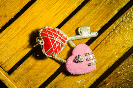 Pink master key and red heart key on wood pattern backgroundの写真素材