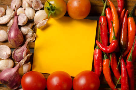 Yellow note with chilli,tomato,shallot and garlic on wood backgroundの写真素材
