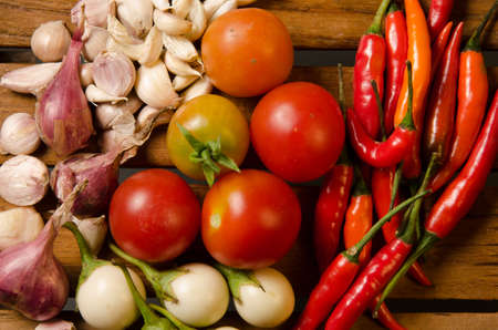 Chilli,tomato,shallot and garlic on wood backgroundの写真素材