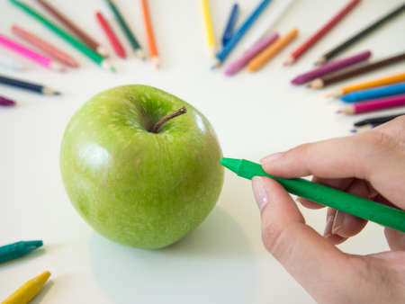 looks like drawing an apple with the colorful crayonの写真素材