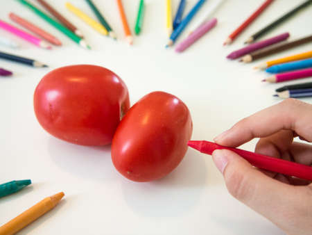 looks like drawing tomatos with the colorful crayonの写真素材