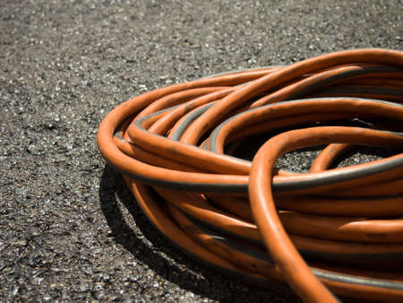 The Orange Extension Cord on the Ground at the Constructionsiteの写真素材