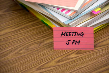Meeting 5 PM; The Pile of Business Documents on the Desk