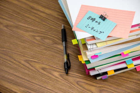 Meeting 8 PM; The Pile of Business Documents on the Deskの写真素材