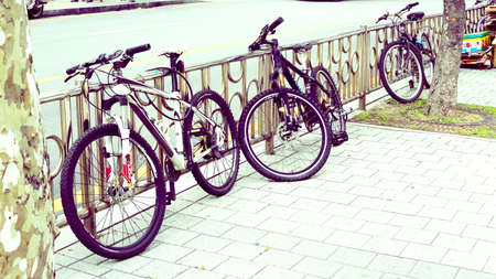 city bikes in row on the road in the daytime. national bicycle day. vintage background. outdoor conceptの写真素材