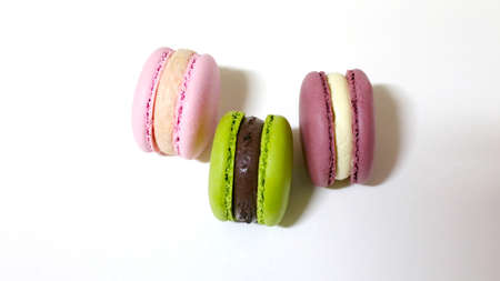 three colors of macaroon in white background. pink green brown. closeup. national biscuit dayの写真素材