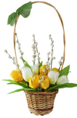 arrangement of artificial flowers and pussy willows in braided basket isolated on white backgroundの写真素材