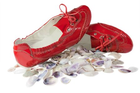 Red lady ballet flat shoes and seashells isolated on white backgroundの写真素材