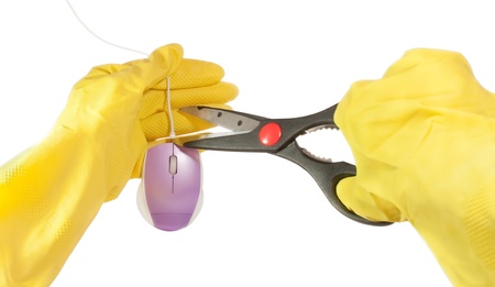 Hands in yellow gloves hold scissors and cutting cable of computer mouse, isolated on white backgroundの写真素材