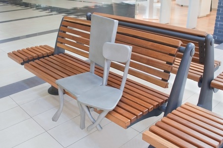 Sculpture of two chairs sitting on a bench in shopping mallの写真素材