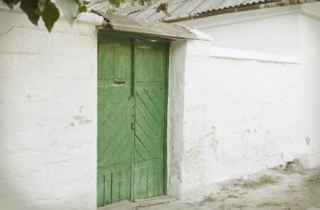 Green Wooden vintage door to the whitewashed buildingの写真素材