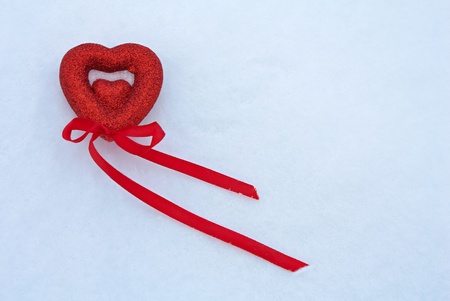 Red beautiful heart - Valentine with ribbon in the snow.の写真素材
