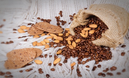 pile of chocolate cookies, fresh coffee beans and almonds on canvas backgroundの写真素材