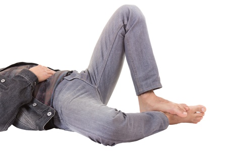 legs of young male lying on the floor, isolated on white backgroundの写真素材