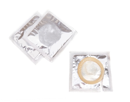 Yellow condom with open pack on white backgroundの写真素材