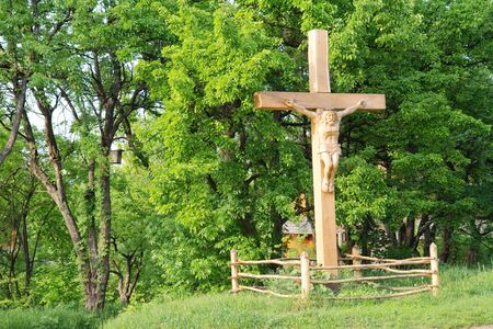 Jesus crucified on the cross, a wooden statue, spring landscapeの写真素材