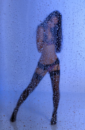 Young sexy woman standing under the rainの写真素材