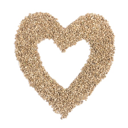 Hemp seeds in heart shape on white backgroundの写真素材
