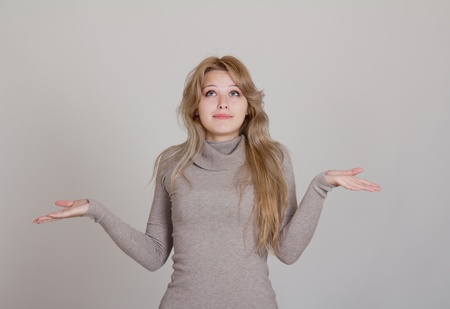 Portrait of a beautiful slim businesswoman in gesture of asking and confusionの写真素材
