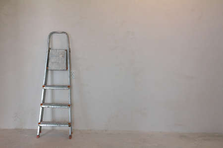 home improvement: dirty ladder near the wallの写真素材
